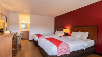 Una habitación de hotel con dos camas, un escritorio y una silla.