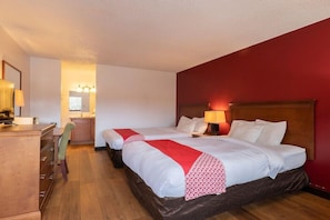 Una habitación de hotel con dos camas, un escritorio y una silla.