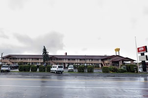 Un motel de dos pisos, con estacionamiento y un letrero de Denny's.