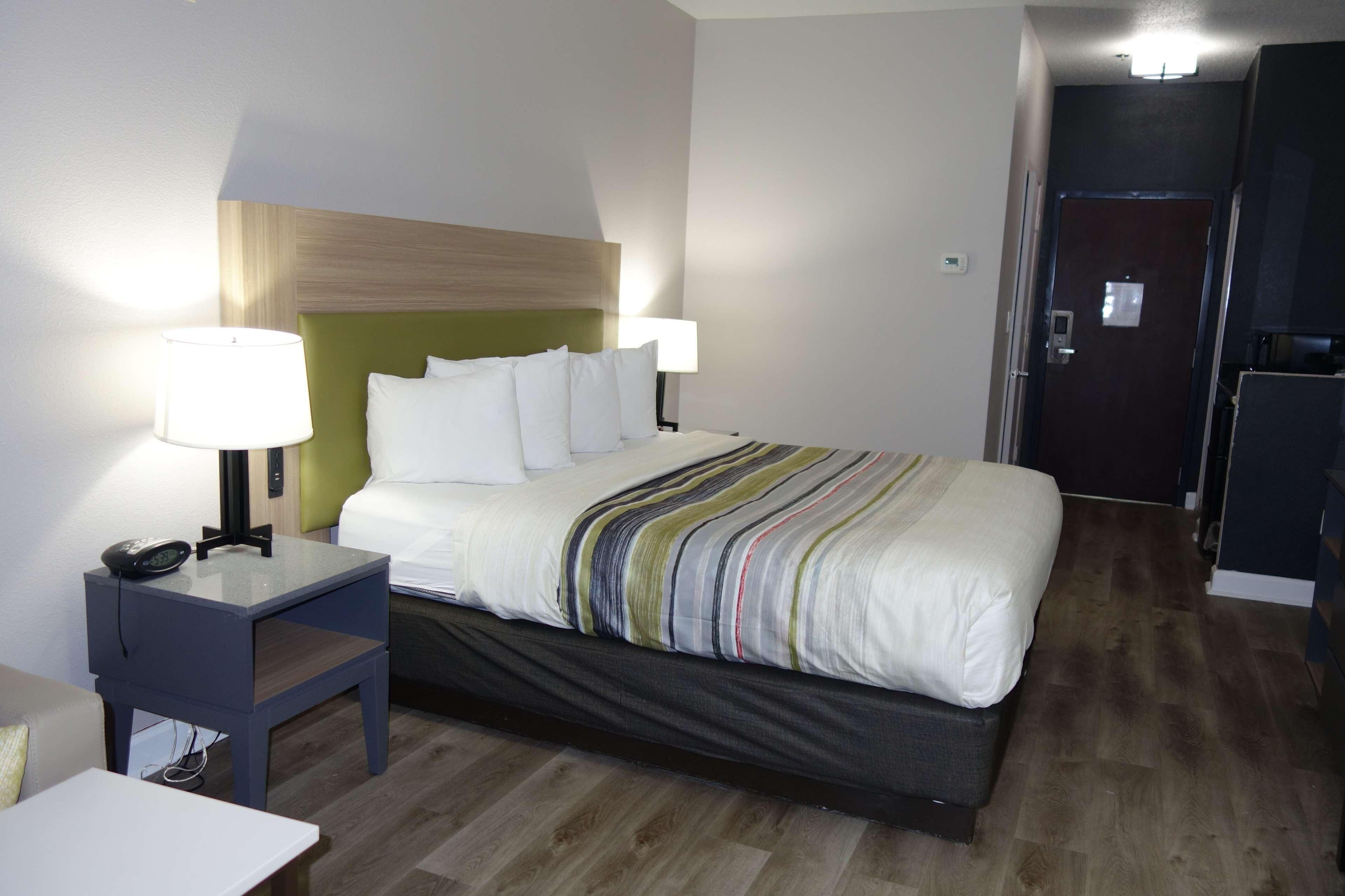 Ein Hotelzimmer mit einem Bett, Nachttischlampen, einem Telefon und einem kleinen Tisch.