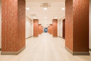 A long, well-lit hallway with patterned walls and a tiled floor, leading to a door at the end. - Radisson Hotel St. Paul Downtown (St. Paul)