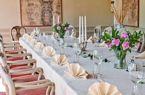 A long dining table with white tablecloth, candles, and pink flowers. - Radisson Hotel St. Paul Downtown (St. Paul)