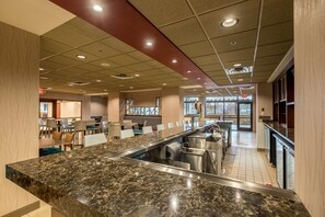 A modern hotel lobby with a marble reception desk, seating area, and large windows. - Radisson Hotel St. Paul Downtown (St. Paul)