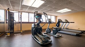 Un gimnasio con cintas de correr, elípticas y bicicletas estáticas.