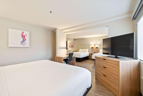 A hotel room with a large bed, a desk, a TV, and a bathroom visible through an open door. - Best Western Lake Oswego Portland Hotel Suites (Lake Oswego)
