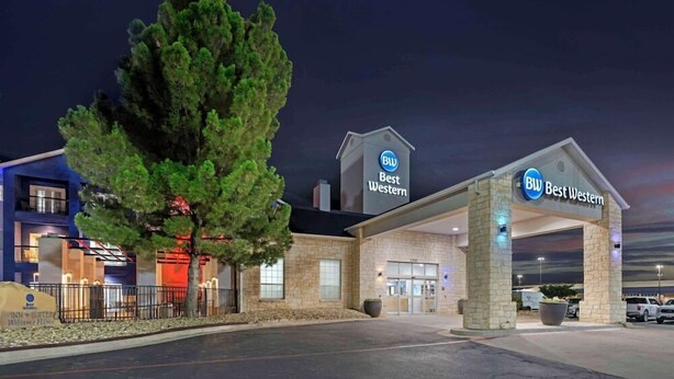 A Best Western hotel with a stone facade, a large welcoming entrance, and a tree in front. - Best Western Lubbock West Inn and Suites (Lubbock)