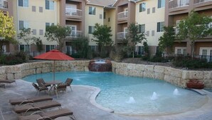 A hotel courtyard with a swimming pool, lounge chairs, and a hot tub. - Best Western Lubbock West Inn and Suites (Lubbock)