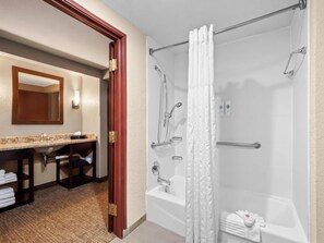 A modern bathroom with a bathtub, shower, and a vanity with a mirror and sink. - Best Western Lubbock West Inn and Suites (Lubbock)