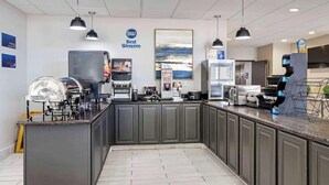 A modern kitchen area with a coffee station, a large island, and a sign reading "Best Western." - Best Western Lubbock West Inn and Suites (Lubbock)
