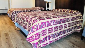 Hotelkamer met twee bedden, een donker hoofdeinde, een wandlamp en een lijst met een afbeelding.