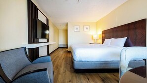 A hotel room with a bed, a TV mounted on the wall, a desk, and two chairs. - King City Motel by OYO Pasco (Pasco)