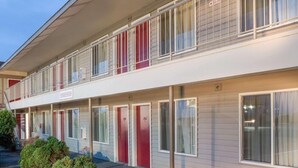 A two-story motel with a row of rooms on the ground floor and a balcony on the upper floor. - King City Motel by OYO Pasco (Pasco)