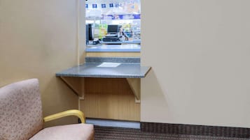 A corner of a room with a chair, a counter, and a vending machine area in the background.