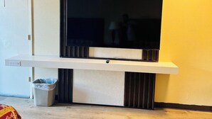 A modern living room with a flat-screen TV mounted on a white console table. - King City Motel by OYO Pasco (Pasco)