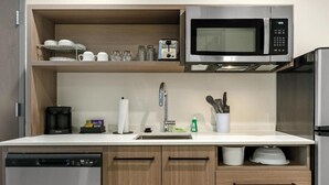 Een moderne keuken met een inbouwvaatwasser, een magnetron en een koelkast.