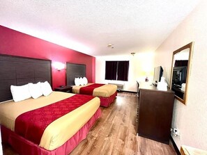 A hotel room with two beds, a desk, a television, and a mirror. - Econo Lodge Oacoma - Chamberlain West (Oacoma)