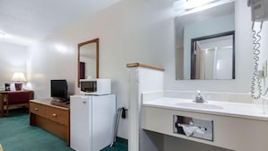 A hotel room with a desk, a television, a microwave, a refrigerator, a sink, and a mirror. - Econo Lodge Oacoma - Chamberlain West (Oacoma)