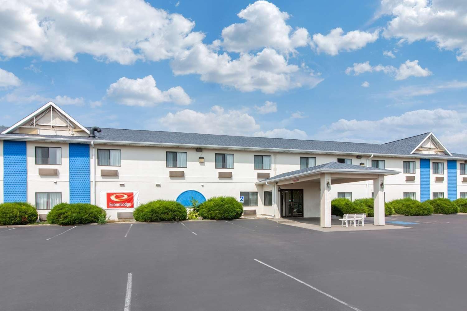 Un motel à deux étages, doté d’une entrée abritée et d’un parking.