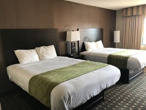 Two double beds with white linens and green accents, a nightstand with a lamp, and a window with curtains. - Red Roof Inn Kimball, TN - I-24 (South Pittsburg)