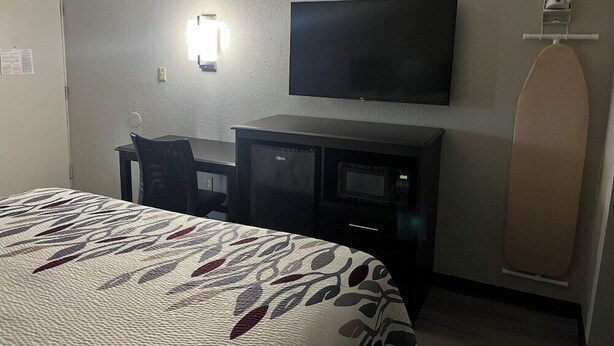 A hotel room with a bed, a desk, a television, and a microwave. - Red Roof Inn Kimball, TN - I-24 (South Pittsburg)