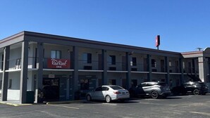 A Red Roof Inn with a parking lot and several cars parked in front. - Red Roof Inn Kimball, TN - I-24 (South Pittsburg)