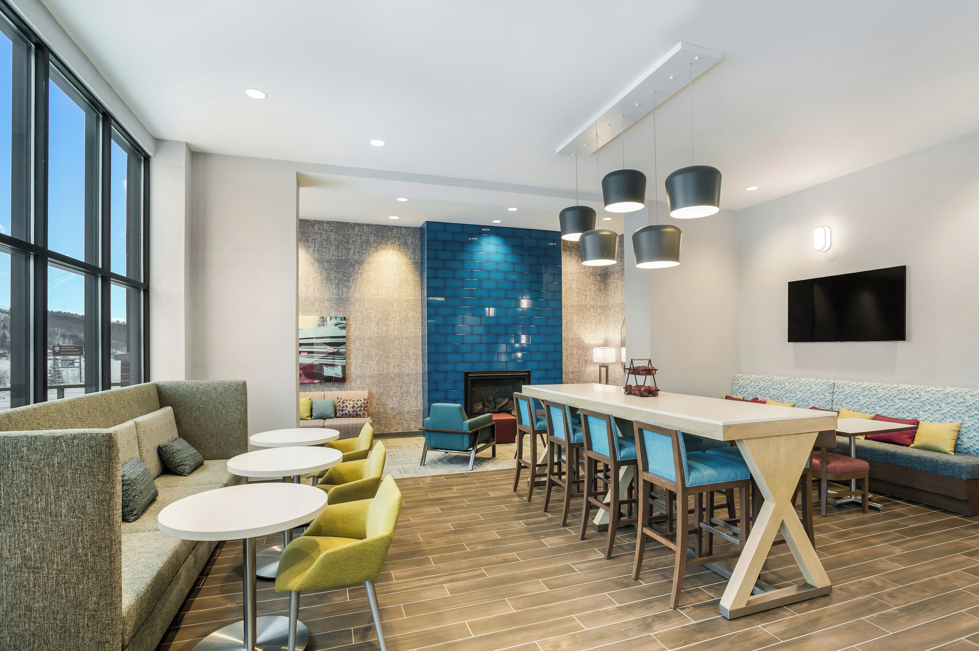 A modern lounge area with a bar, seating, and a fireplace.