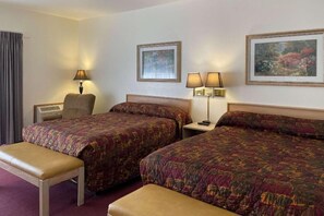 A hotel room with two beds, a bench, a desk, a lamp, and a picture on the wall. - Edgewater Inn and Suites, Ascend Hotel Collection (Coos Bay)