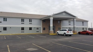 Un hôtel à plusieurs étages, doté d’une entrée couverte et d’un parking.