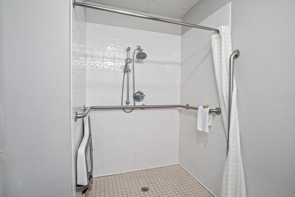 A shower with a grab bar, a handheld showerhead, and a curtain. - Blue Water Inn & Suites, Bw Signature Collection (Sneads Ferry)