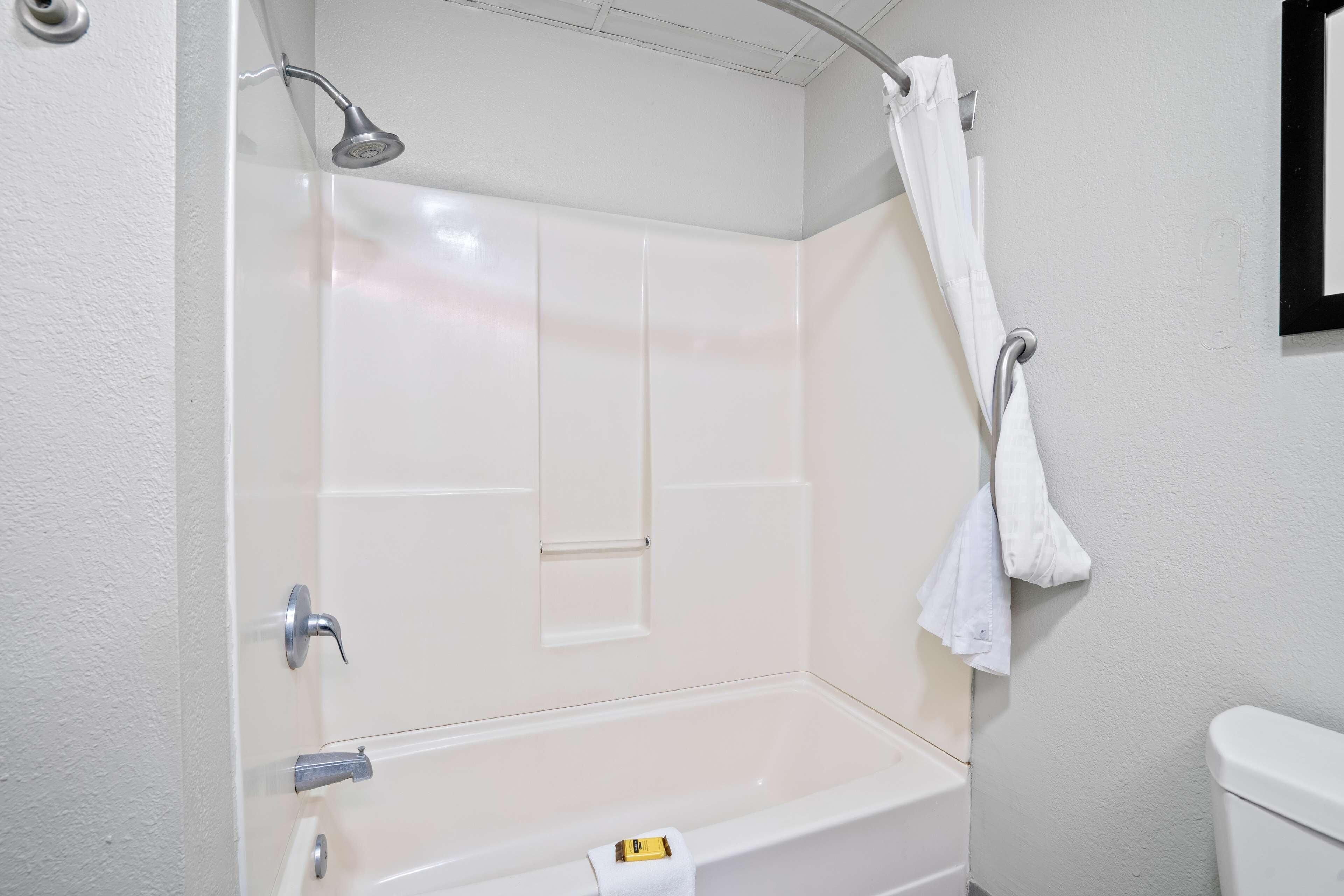 Ein Badezimmer mit Badewanne, Dusche, Toilette und Handtuchhalter.