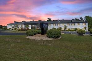 A hotel with a modern design, a covered entrance, and a well-maintained lawn. - Blue Water Inn & Suites, Bw Signature Collection (Sneads Ferry)