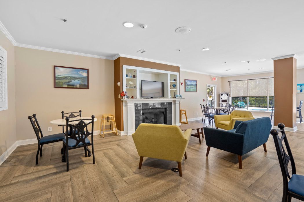 A living room with a fireplace, a television, and a dining area with chairs and a table.