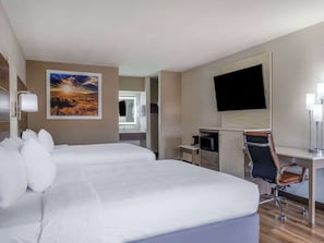 A hotel room with a large bed, a desk with a chair, a flat-screen TV, and a painting on the wall. - Days Inn by Wyndham Clemson (Clemson)