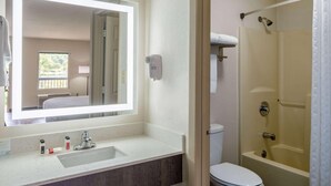 A bathroom with a large mirror, a sink, a toilet, and a shower. - Days Inn by Wyndham Clemson (Clemson)