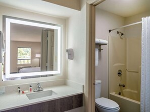 A bathroom with a large mirror, a sink, a toilet, and a shower. - Days Inn by Wyndham Clemson (Clemson)