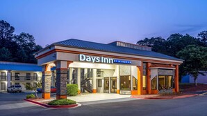 Ein Hotel Days Inn by Wyndham mit modernem Design, inklusive überdachter Zufahrt und Parkplatz.