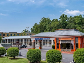 A Days Inn by Wyndham with a parking lot, a gazebo, and a building with orange and grey architecture. - Days Inn by Wyndham Clemson (Clemson)