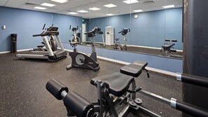 A gym with various exercise equipment, including treadmills, stationary bikes, and weight machines. - Ramada by Wyndham Cocoa (Cocoa)