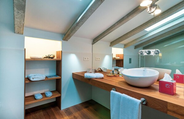 Une salle de bain moderne avec un grand lavabo, des étagères en bois et un miroir.