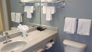 Une salle de bain équipée d’un lavabo, d’un miroir, d’un porte-serviettes et de toilettes.