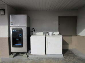A utility room with an ice dispenser, a washing machine, and a dryer. - Sonesta Essential Augusta (Augusta)