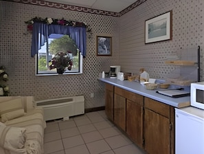A kitchen with a window, a microwave, a sink, and cabinets. - Sonesta Essential Augusta (Augusta)
