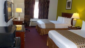 Une chambre d’hôtel avec deux lits, un bureau, une chaise, une télévision et une lampe.
