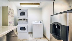 A compact laundry room with a washing machine, dryer, and a Scotchman iron station. - Motel6 Hagerstown, MD (Hagerstown)