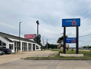 Un motel avec une enseigne indiquant « Motel 6 » et une autre enseigne indiquant « ENTRÉE 6 ».