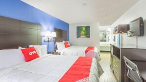 Une chambre d’hôtel avec deux lits, une télévision, un bureau et une salle de bain.