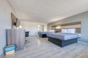 A hotel room with two beds, a desk, a trash bin, and a wall-mounted TV. - OYO Hotel Whitely City Hwy 27 KY (Stearns)