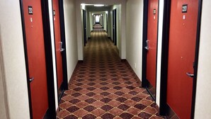 Ein Hotelkorridor mit roten Türen, jeweils mit den Nummern 2201 und 2202, der zu Zimmern führt.
