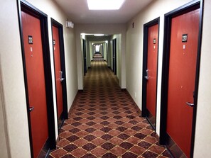 A hotel hallway with red doors numbered 2201 and 2202, leading to rooms.