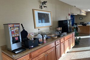Ein Selbstbedienungs-Frühstücksbereich mit Kaffeemaschine, Toaster und einer Auswahl an Speisen.